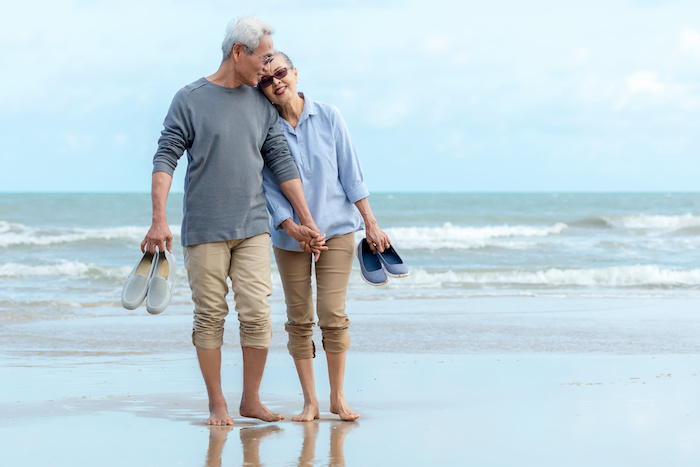 Lifestyle asian senior couple happy walking hug and relax on the beach.  Tourism elderly family travel leisure and activity after retirement in vacations and summer.
