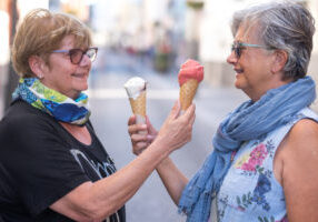 Two pretty elderly women look into each other's eyes with an ice cream cone in their hands Two pretty elderly women look into each other's eyes with an ice cream cone in their hands
